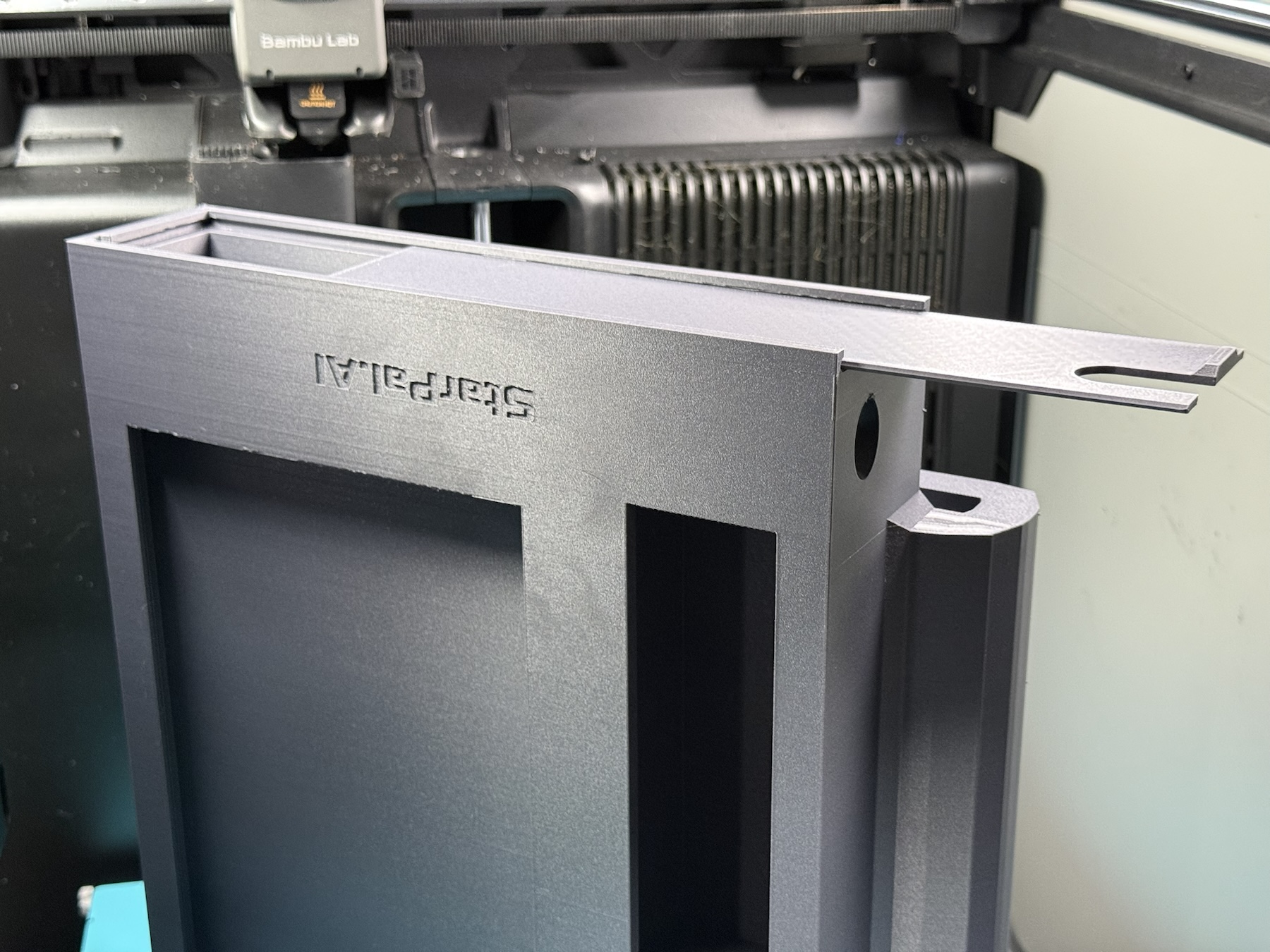 Black custom 3D printed electronics enclosure with an extended mounting feature